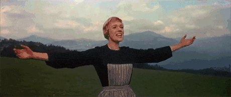 Julie Andrews as Maria spinning with her arms outstretched on a mountain meadow in the opening of The Sound of Music.