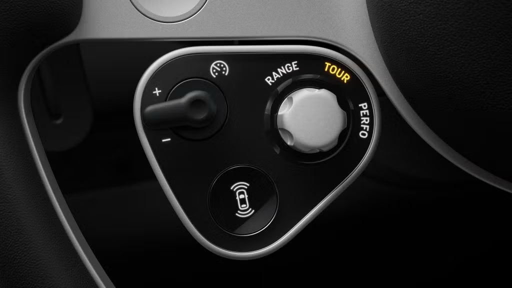 Close-up of a satellite control pod on the Ferrari Luce steering wheel, with a physical dial and toggle switch