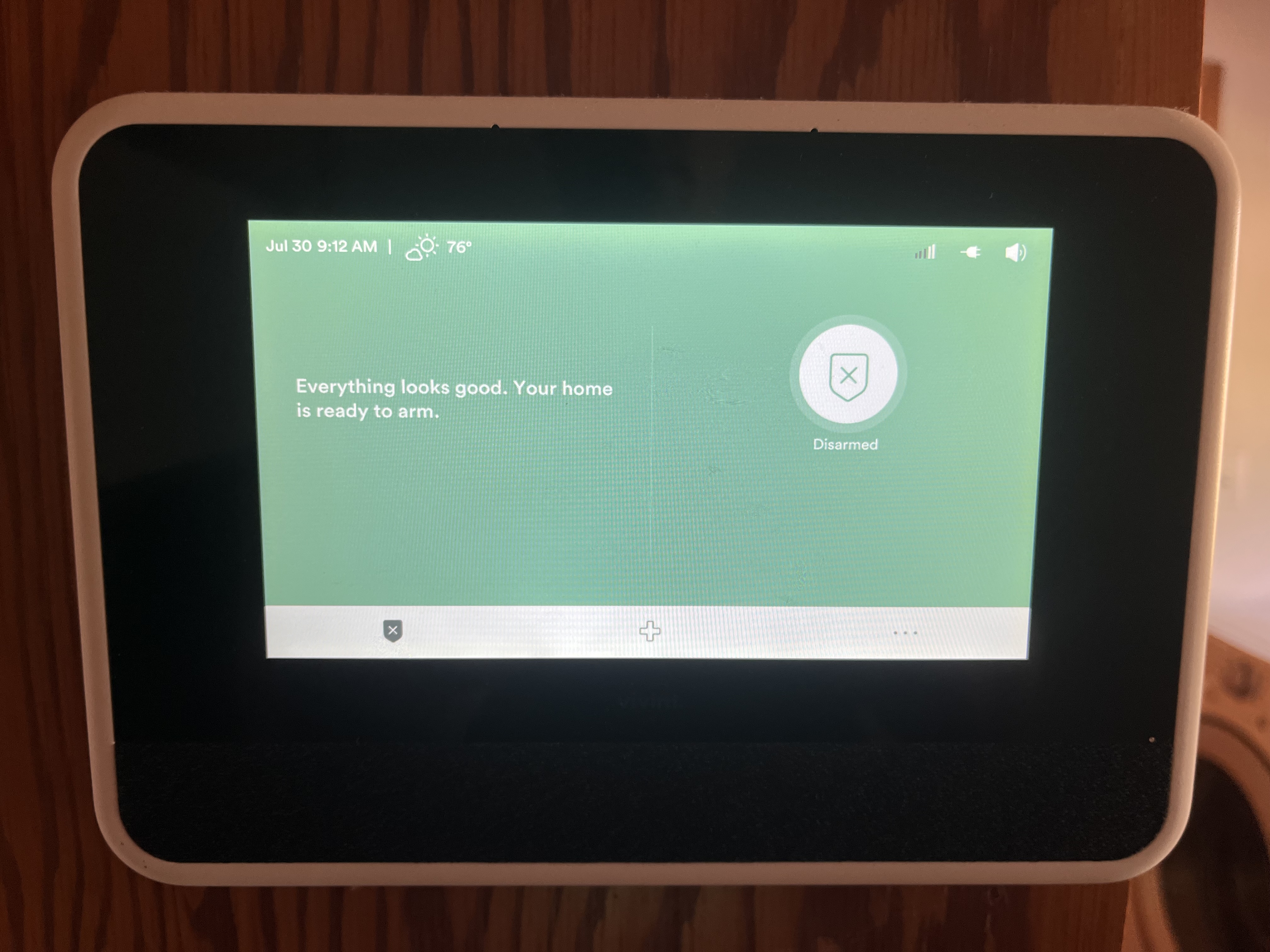 A home security touchscreen panel reading "Everything looks good. Your home is ready to arm."